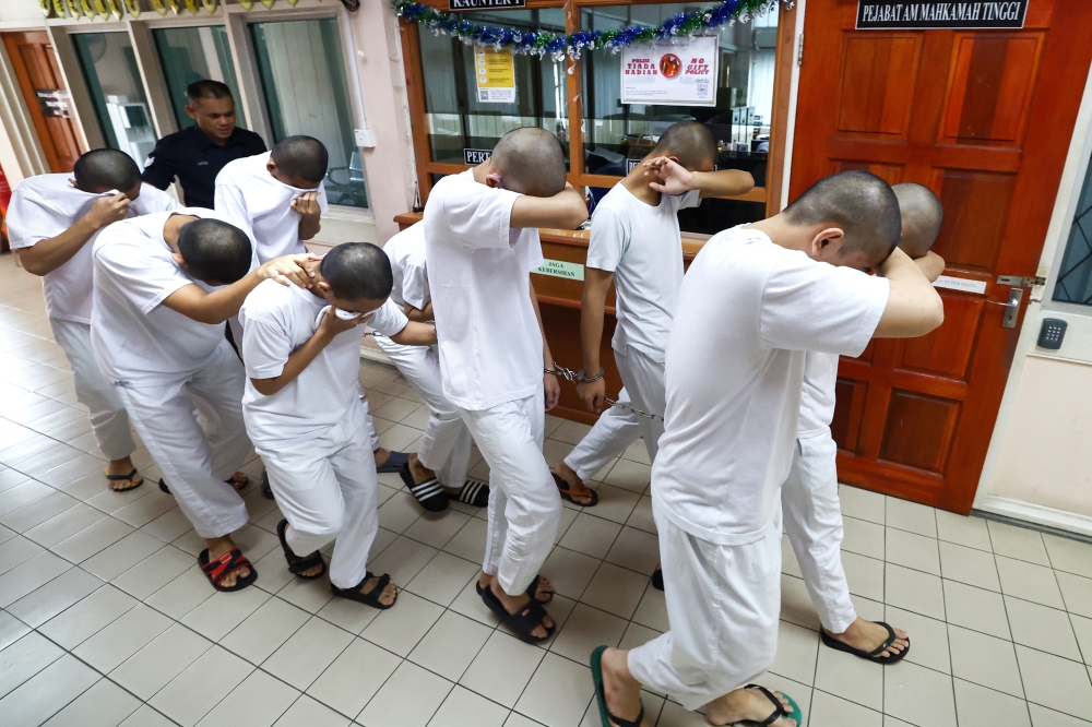 Some of the 13 teenagers, aged 16 to 19, who have been ordered to enter their defence on charges of murdering a Lahad Datu Vocational College student, arrive at the Tawau High Court March 11, 2025. — Bernama pic