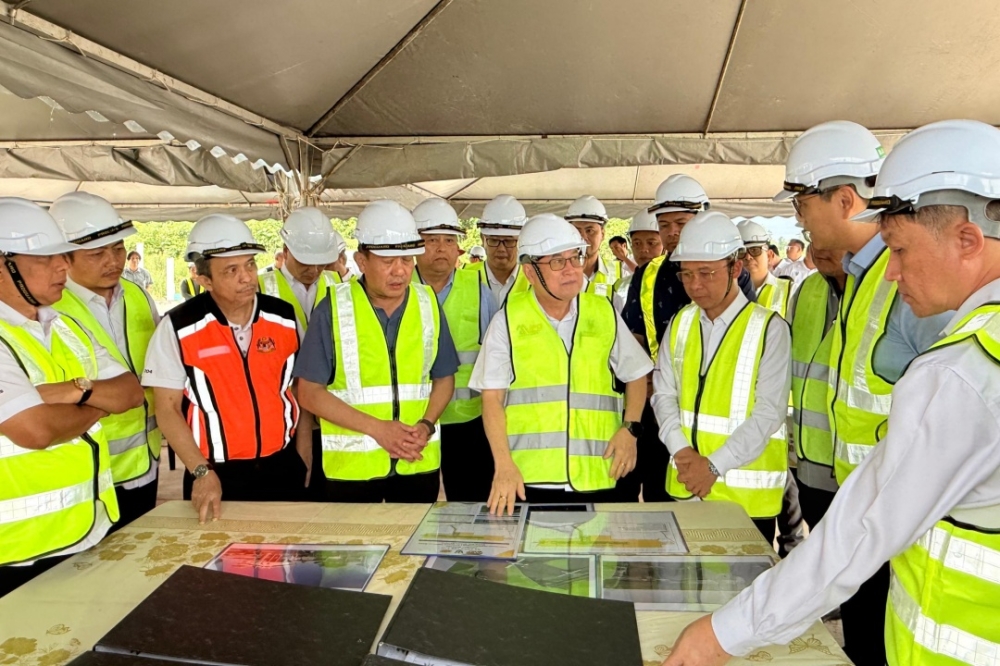 Uggah (front, 5th left) being briefed on the progress of the Bebuling STOLport. — The Borneo Post pic