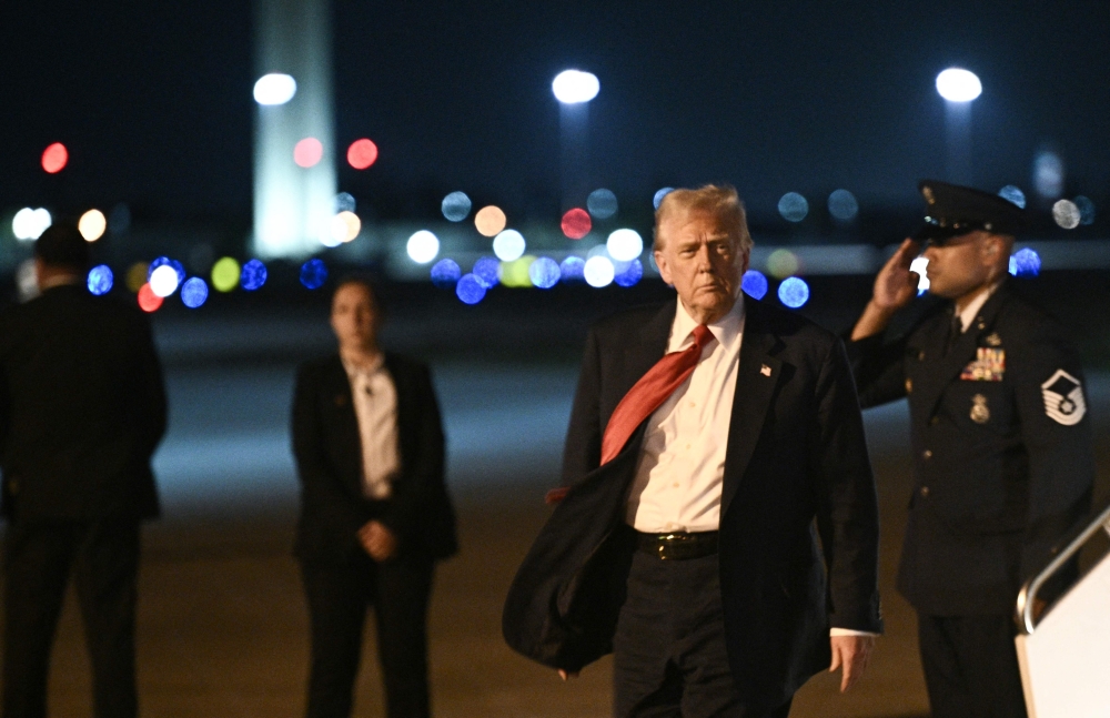 US President Donald Trump steps off Air Force One as he arrives at Palm Beach International Airport in West Palm Beach, Florida, on March 14, 2025. — AFP pic
