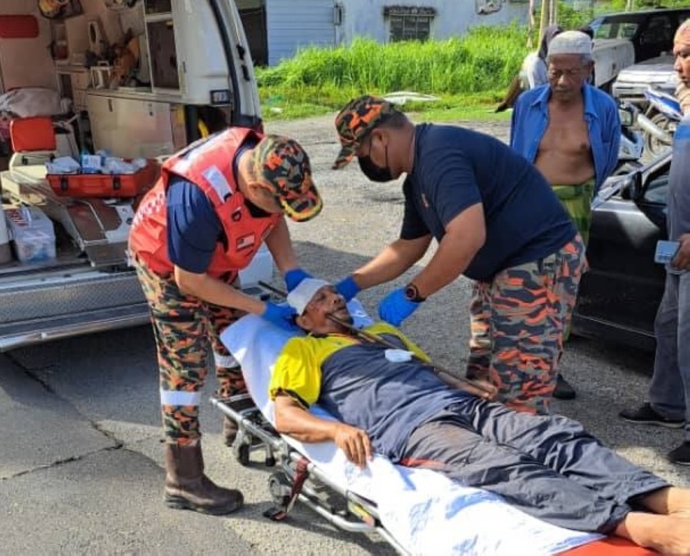 Emergency personnel attend to Azlam Mahmood at the scene of the accident. — Picture via Facebook