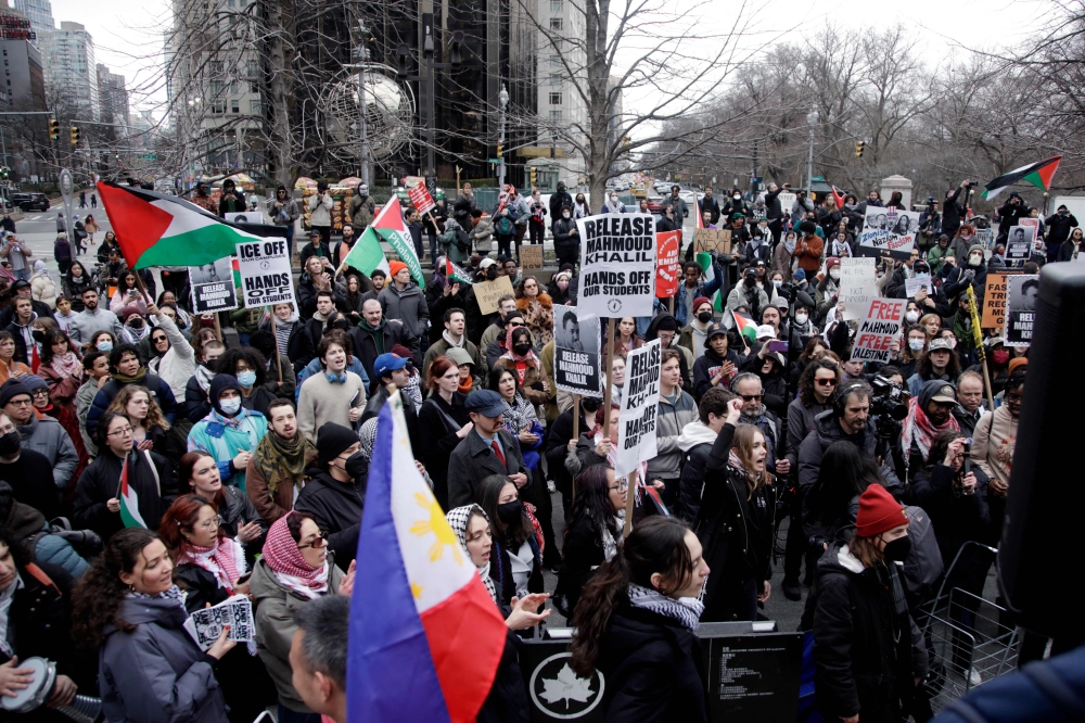 Pro-Palestinian activists hold signs and wave flags as they participate in a 