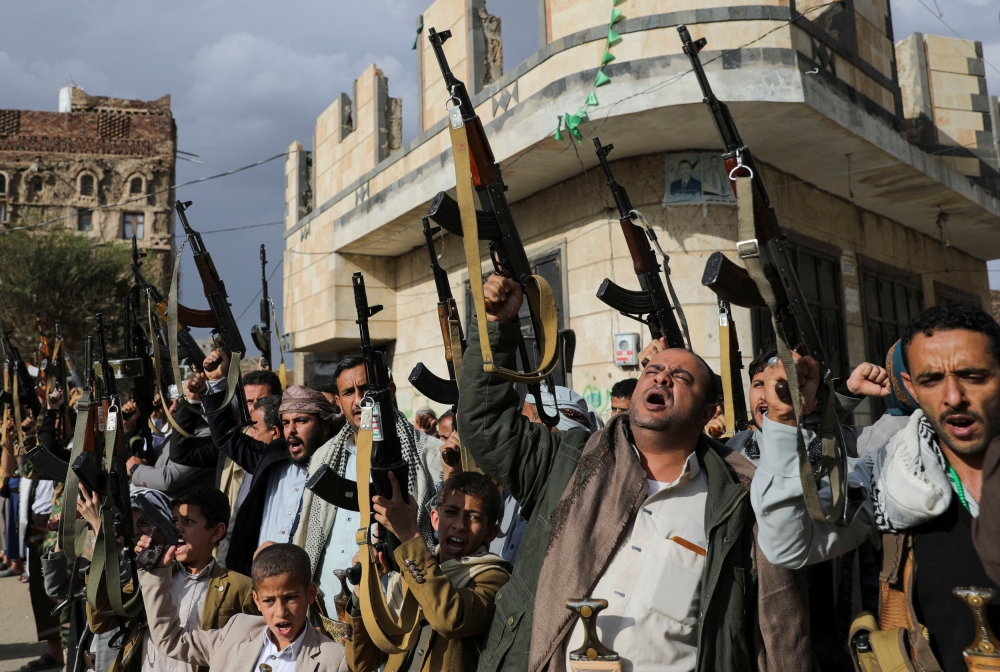 Houthi supporters hold up their weapons during a protest against Israel's blockade of aid into the Gaza Strip, in Sanaa March 11, 2025. — Reuters pic