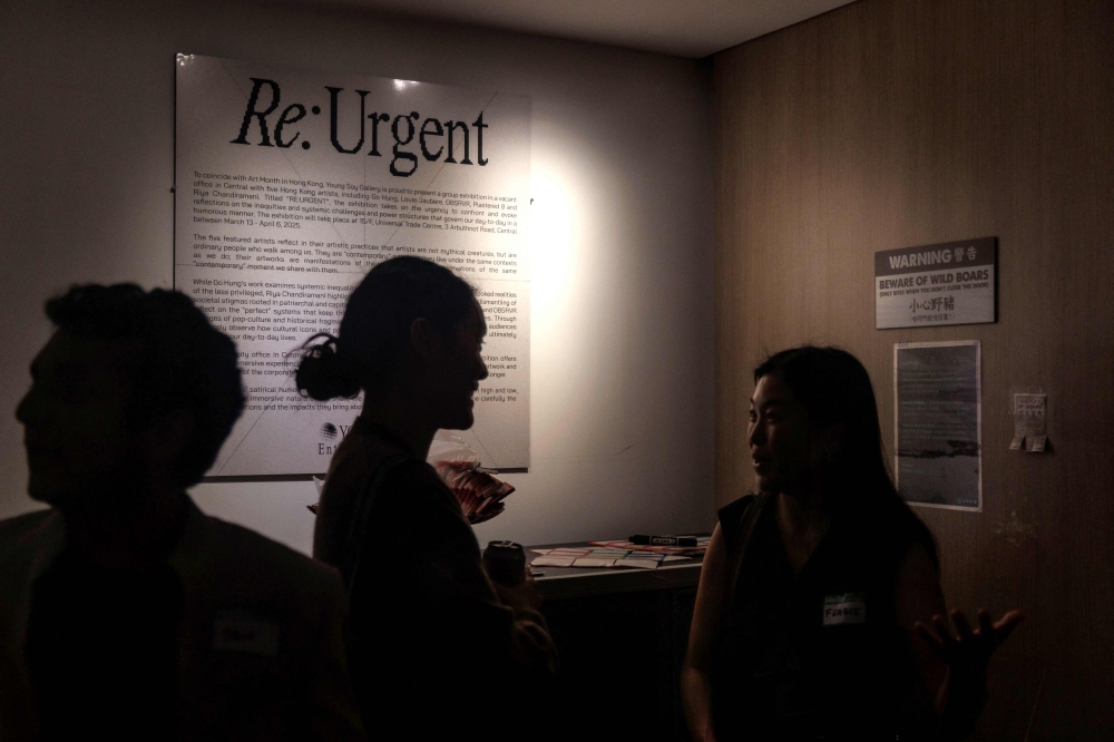 Visitors attend the opening of an exhibition titled 'RE:URGENT' by Young Soy Gallery with five Hong Kong artists including Go Hung, Louie Jaubere, OBSRVR, Plastered 8 and Riya Chandiramani, at a vacant office in Hong Kong March 13, 2025. — AFP pic