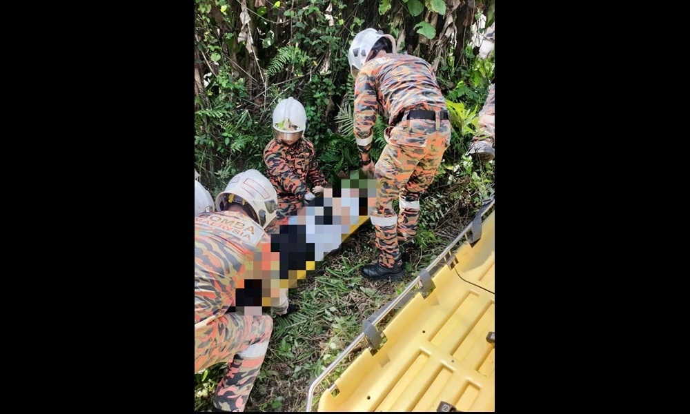 Handout photo shows firefighters place one of the victims on a stretcher. — Picture courtesy of the Fire and Rescue Department
