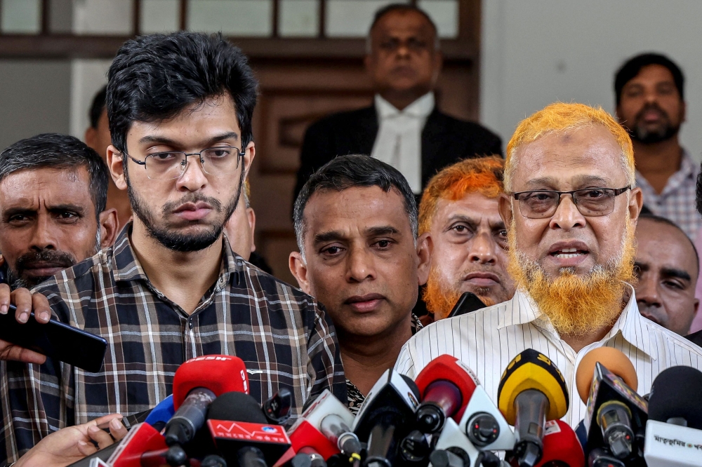 Barkat Ullah (R), father of Abrar Fahad, speaks to the media after the High Court’s verdict. — AFP pic