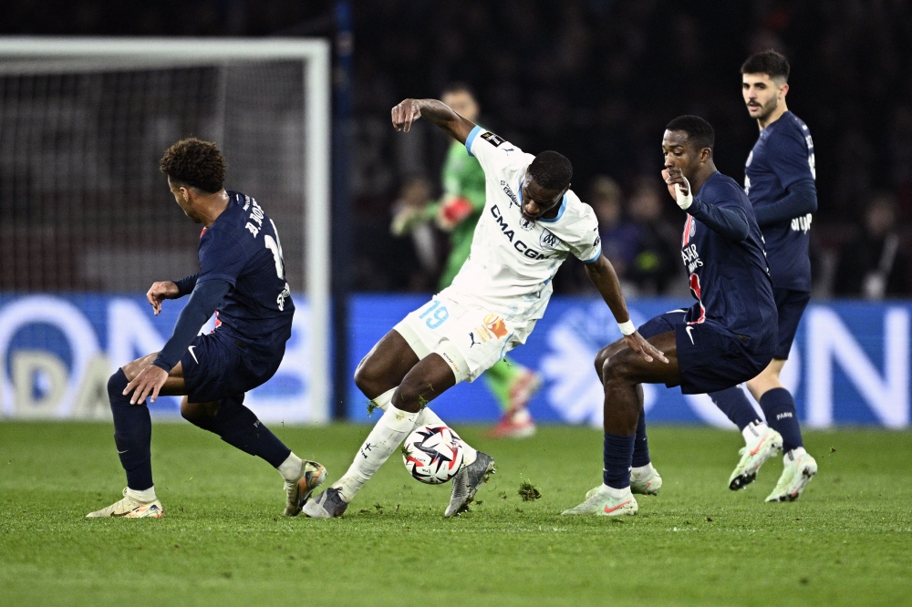 Marseille's Central African Republic's midfielder Geoffrey Kondogbia (C) fights for the ball with Paris Saint-Germain's Desire Doue during the match yesterday. — AFP pic