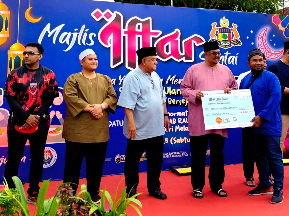 Melaka Chief Minister Datuk Seri Ab Rauf Yusoh (second from right) presents a contribution to a representative of the Heritage Trishaw Association in Bandar Hilir, on March 15, 2025. — Bernama pic