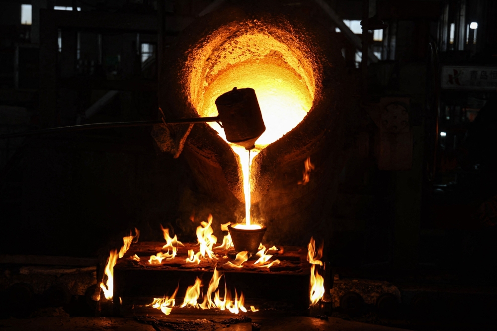 Workers pour molten steel at a factory which produces engine parts in Binzhou, Shandong province March 14, 2025. — AFP pic