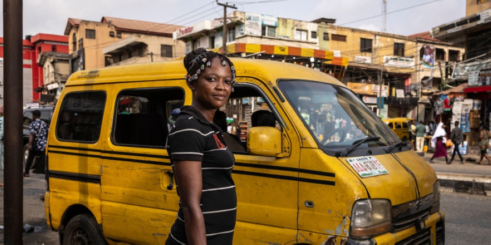 Blessing Onyedinma, 28, a Danfo (minibus) driver, poses for a photograph next to a minibus in in Ikeja Underbridge bus stop in Lagos, on February 21, 2025. — AFP pic