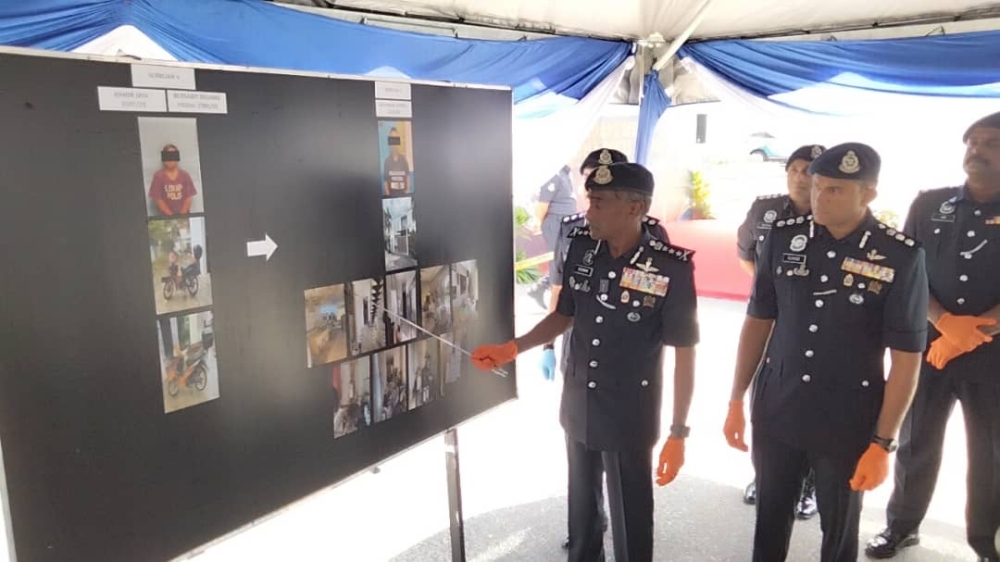 Johor police chief Datuk M. Kumar (left) shares details of the raids at the Iskandar Puteri district police headquarters in Iskandar Puteri today. — Picture by Ben Tan