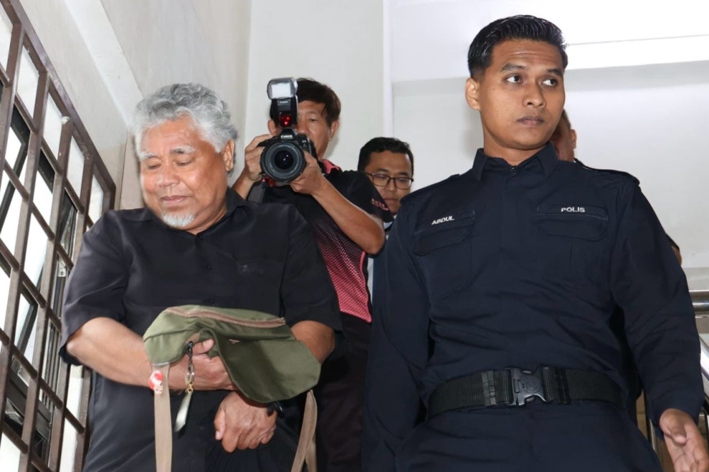 The accused, Abdul Razak Ismail, being escorted by a policeman at the Johor Baru Magistrate’s Court. — Picture by Ben Tan
