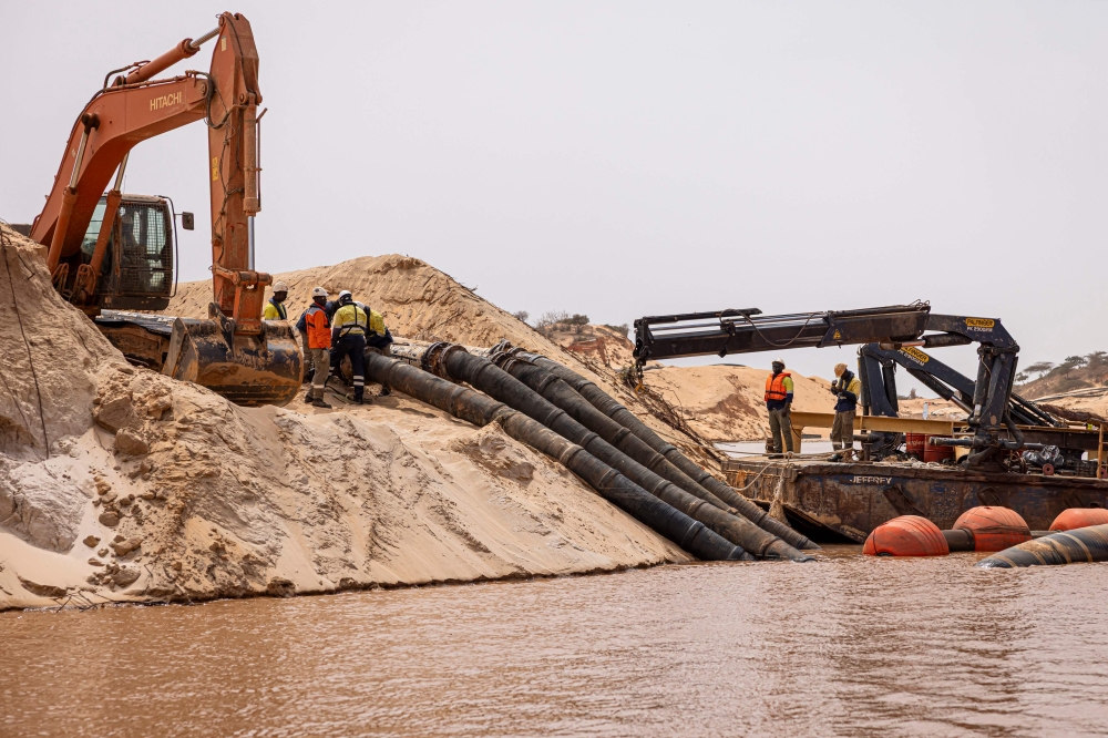 Workers adjust dredging pipes at the Eramet Grande Cote (EGC) floating Wet Concentration Plant (WCP) in the Lompoul desert in Lompoul, on February 12, 2025. The ‘world's biggest mining dredger’ has swallowed up acre after acre of the fertile coastal strip were most of Senegal's vegetables are grown. — AFP pic
