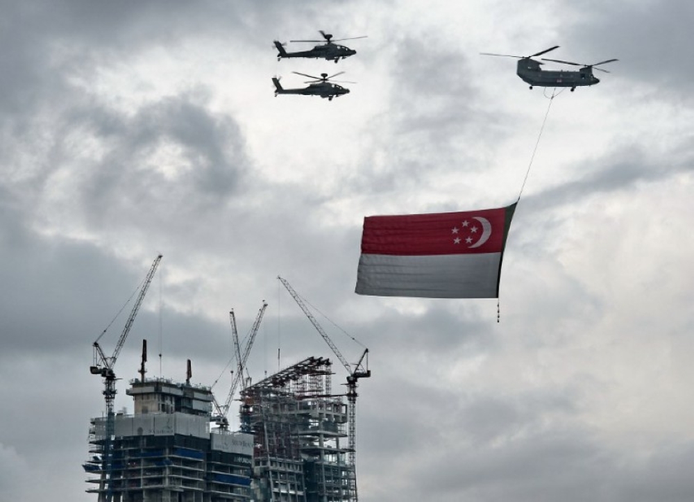 File picture shows a Republic of Singapore Air Force Chinook helicopter (top right) flying a giant national flag on National Day, August 9, 2014. Oracle announced yesterday that it will provide Singapore’s armed forces and defence ministry with an “air-gapped” isolated cloud computing infrastructure. — AFP file pic