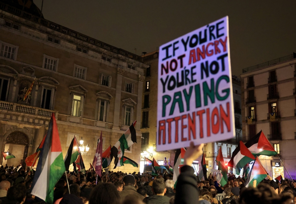 People wave Palestinian flags as they take part in a protest to show support for Palestinians and to call for a halt in arms sales to Israel after it renewed strikes on Gaza, as part of the ongoing conflict between Israel and Hamas, in Barcelona, Spain, March 19, 2025. — Reuters pic