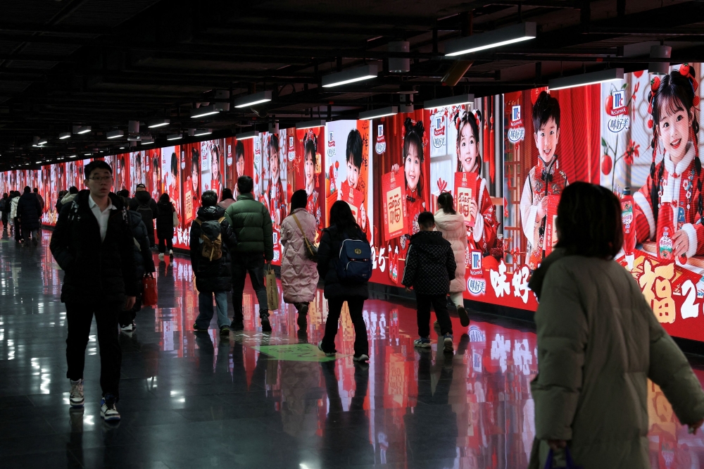 People walk in front of billlboards in a metro station in Shanghai, China, January 16, 2025. China stopped reporting the data for youth joblessness for months after the unemployment rate for 16-24-year-olds hit a record 21.3 per cent in June 2023. — Reuters pic