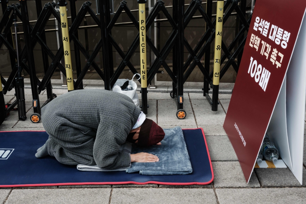 A supporter of impeached President Yoon Suk Yeol prays for the dismissal of his impeachment ahead of the verdict near the Constitutional Court in Seoul. — AFP