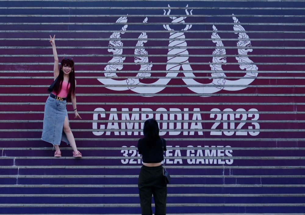 A file photograph shows visitors in front of the logo of the 32nd Southeast Asian (SEA) Games, in Phnom Penh, Cambodia, May 2, 2023. — Reuters pic