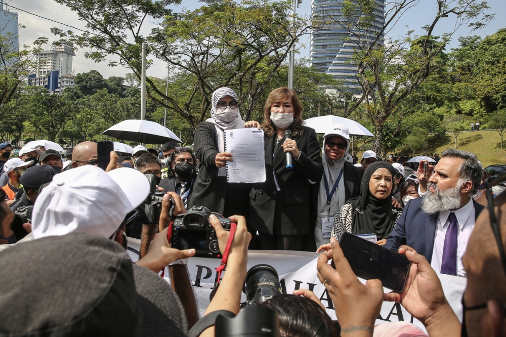 Deputy law minister Mas Ermieyati Samsudin (left) holding up the memorandum she received from Bar president Karen Cheah (right) during Walk for Judicial Independence at Padang Merbok in Kuala Lumpur June 17, 2022. — Picture by Yusof Mat Isa
