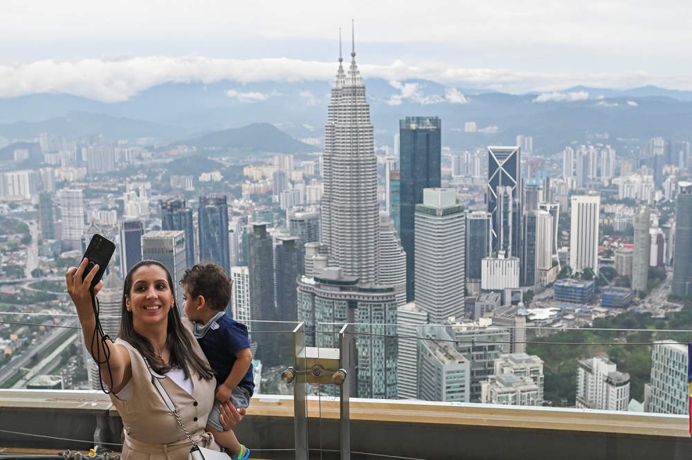 A tourist takes a selfie during a visit to KL Tower in Kuala Lumpur February 14, 2023. — Picture by Miera Zulyana