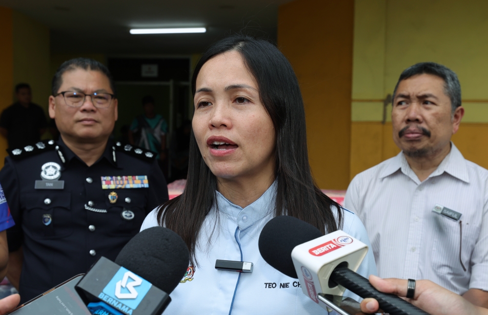 Deputy Communications Minister Teo Nie Ching (centre) speaks to reporters after visiting flood victims at a Temporary Relief Centre (PPS) in Kulai, Johor, on March 21, 2025. — Bernama pic