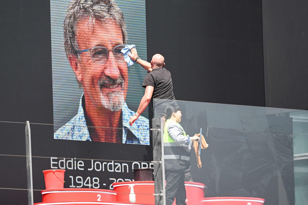 Staff members prepare for a tribute in memory of former Formula One team owner Eddie Jordan before the start of the Formula One Chinese Grand Prix at the Shanghai International Circuit in Shanghai on March 23, 2025. — AFP pic