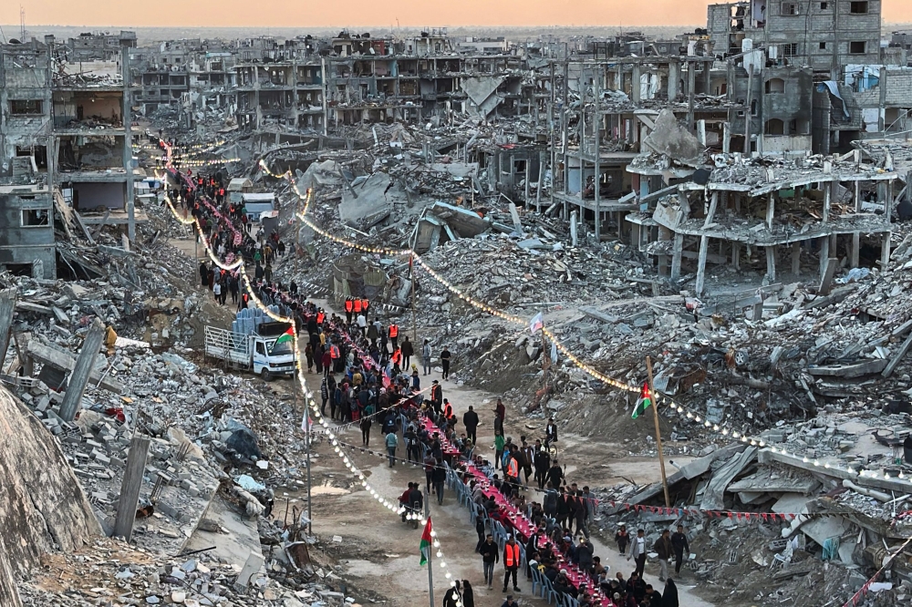 A red-covered table stretching several hundred metres carved a path through mounds of rubble in southern Gaza on Saturday, as families gathered to break their fast during the first day of the Muslim holy month of Ramadan. — AFP pic