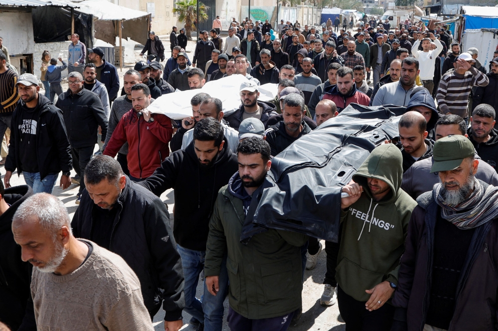 Palestinians carry the bodies of Hamas political leader Salah al-Bardaweel and his wife who died after an Israeli strike on their tent shelter in Khan Younis in the southern Gaza Strip on March 23, 2025. — Reuters pic