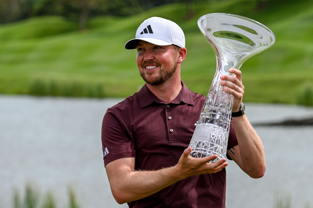England's Richard Mansell poses with the trophy after winning the DP World Tour Singapore Classic golf tournament at Laguna National Golf Resort Club in Singapore March 23, 2025. — AFP pic