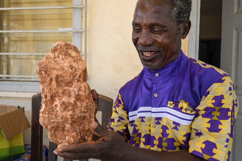 Ivorian Archaeologist Francois Guede Yiode hold a stone used by Homo sapiens 150 000 years ago, at his residence near Abidjan on March 13, 2025. — AFP pic