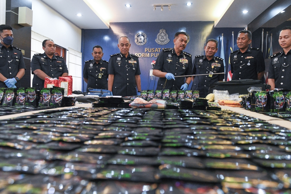 Penang police chief Datuk Hamzah Ahmad displays various types of drugs during a press conference on the arrest of four individuals and the seizure of assorted drugs worth over RM6.7 million in a series of raids across the state from Saturday to yesterday. — Bernama pic
