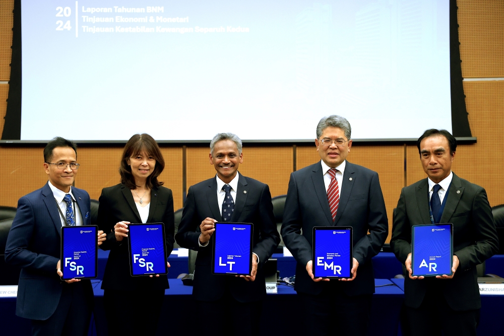 Bank Negara Malaysia Governor Datuk Seri Abdul Rasheed Ghaffour (centre) and other officials hold up the 2024 Annual Report at Sasana Kijang in Kuala Lumpur on March 24, 2025. — Picture by Firdaus Latif