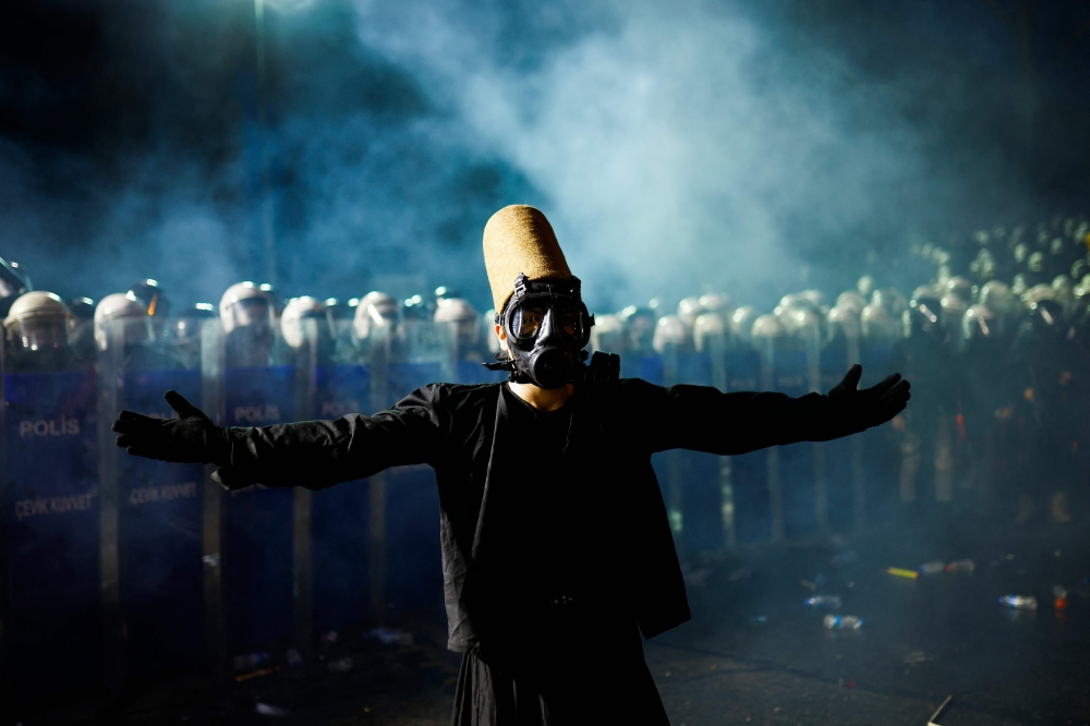 A whirling dervish stands in front of Turkish anti-riot police officers during a rally in support of Istanbul's arrested mayor in Istanbul Municipality, on March 23, 2025. — AFP pic
