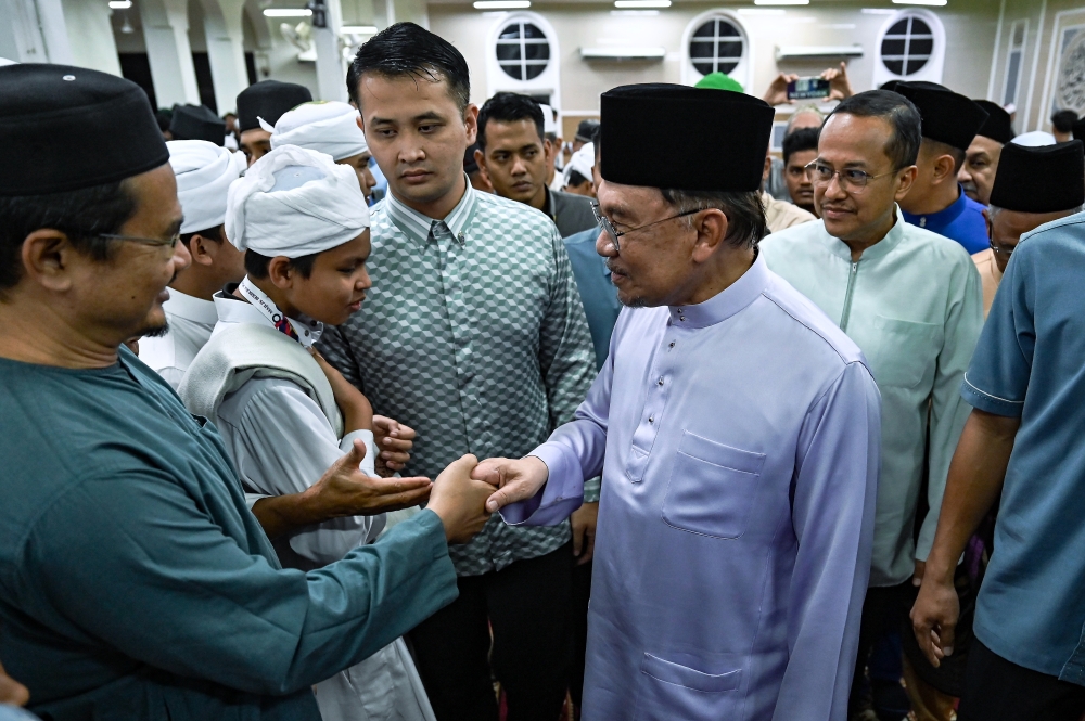 Prime Minister Datuk Seri Anwar Ibrahim (second from right) greets congregants after Maghrib prayers at the State-level MADANI Iftar in Terengganu, held at Sultan Ahmad Mosque, Kemaman, yesterday. — Bernama pic