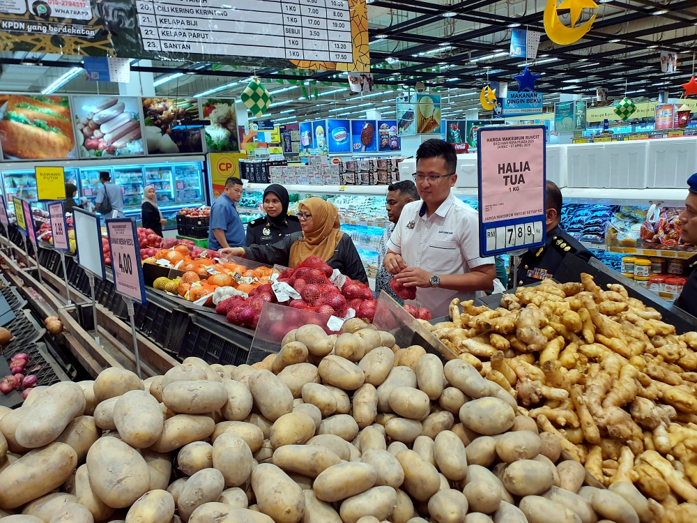 Melaka exco for Entrepreneur Development, Cooperatives, and Consumer Affairs, Allex Seah Shoo Chin (right), inspected the prices of essential goods after officiating the implementation of the Festive Season Maximum Price Control Scheme for Hari Raya Aidilfitri 2025 at a supermarket in MITC Ayer Keroh. — Bernama pic