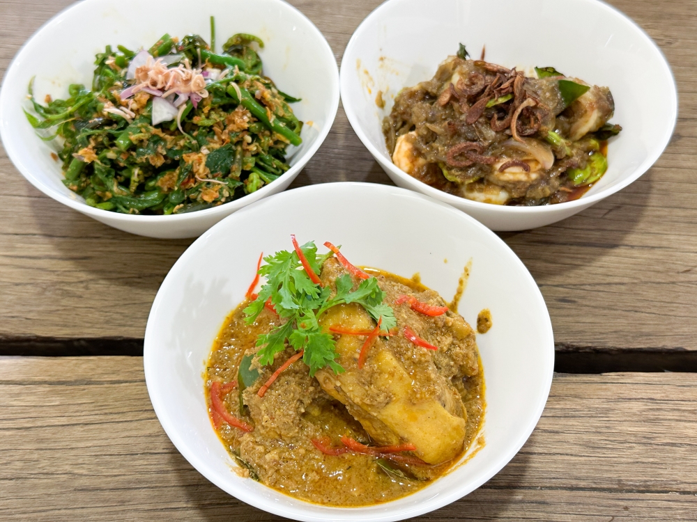 The soft opening menu features dishes (left to right) like Kerabu Lemak Sayur Paku, Chicken Kapitan and Petai Sambal Udang — Picture by Lee Khang Yi
