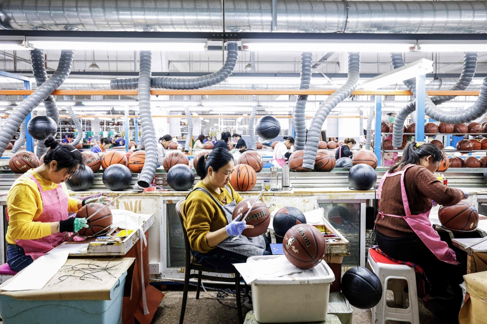 Employees produce basketballs that will be exported to Europe at a factory in Sihong, Jiangsu province March 25, 2025. — AFP pic