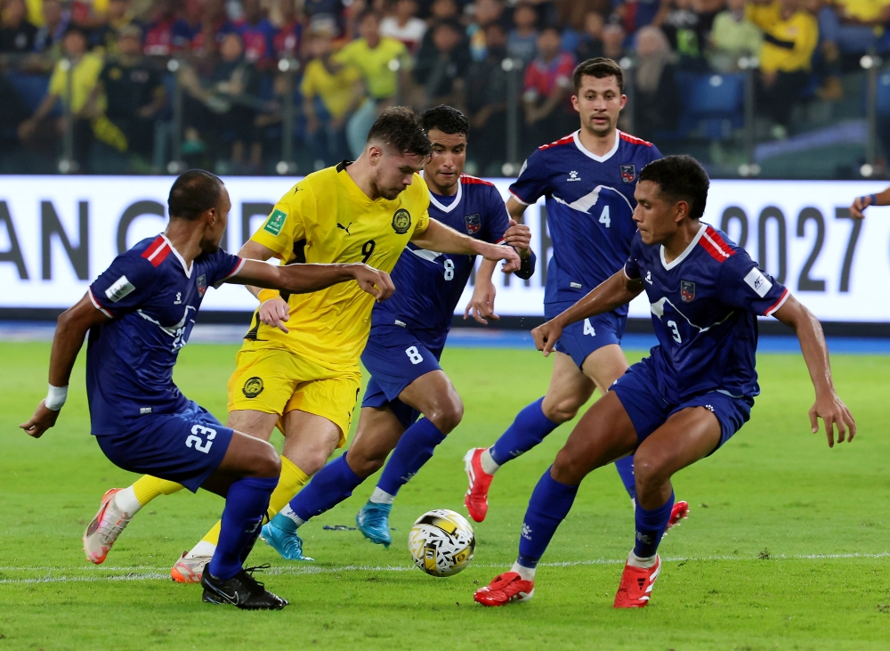 Malaysia’s Romel Morales is blocked by several Nepalese players during the third-round match of the 2027 Asian Cup qualifiers for Group F at Sultan Ibrahim Stadium in Iskandar Puteri March 25, 2025. — Bernama pic
