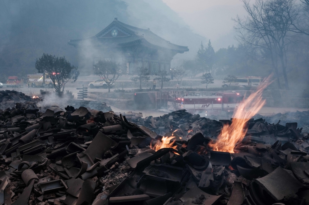 Embers remain among the debris after most of the buildings were burned to the ground in a wildfire at Gounsa Temple in Uiseong on March 26, 2025. — AFP pic