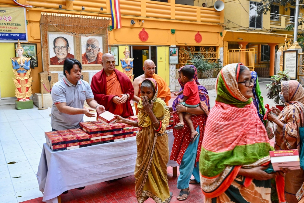 This photograph taken on March 20, 2025 shows needy Muslims receiving free fast-breaking iftar meals from Buddhist monks during the Islamic holy fasting month of Ramadan at the Dharmarajika Buddhist Monastery in Dhaka. A Buddhist monastery in Bangladesh has found renown for opening its doors to the needy during the Islamic month of Ramadan -- a beacon of interfaith harmony in a time of religious tension. — AFP pic