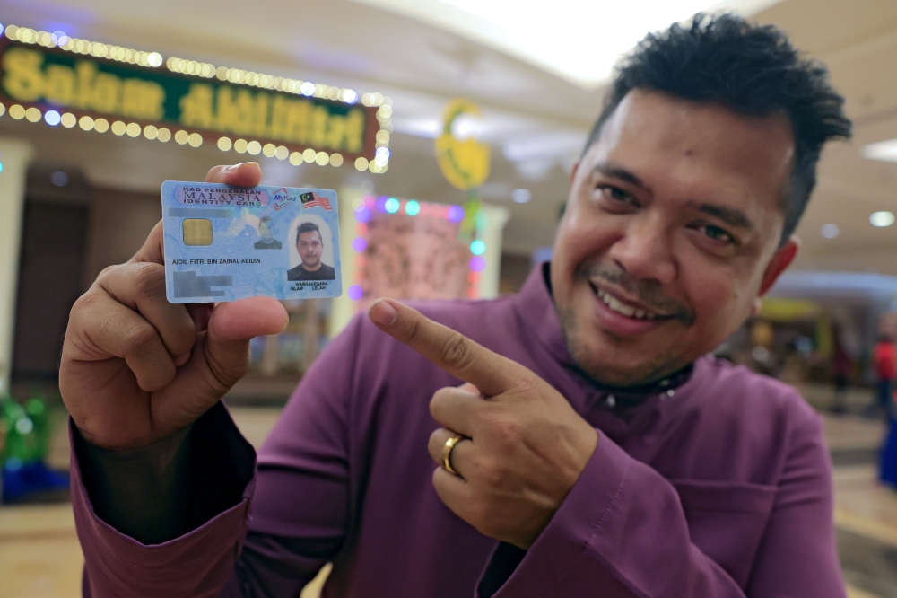 Aidil Fitri Zainal Abidin holds his MyKad during an interview in Seremban March 28, 2025. — Bernama pic