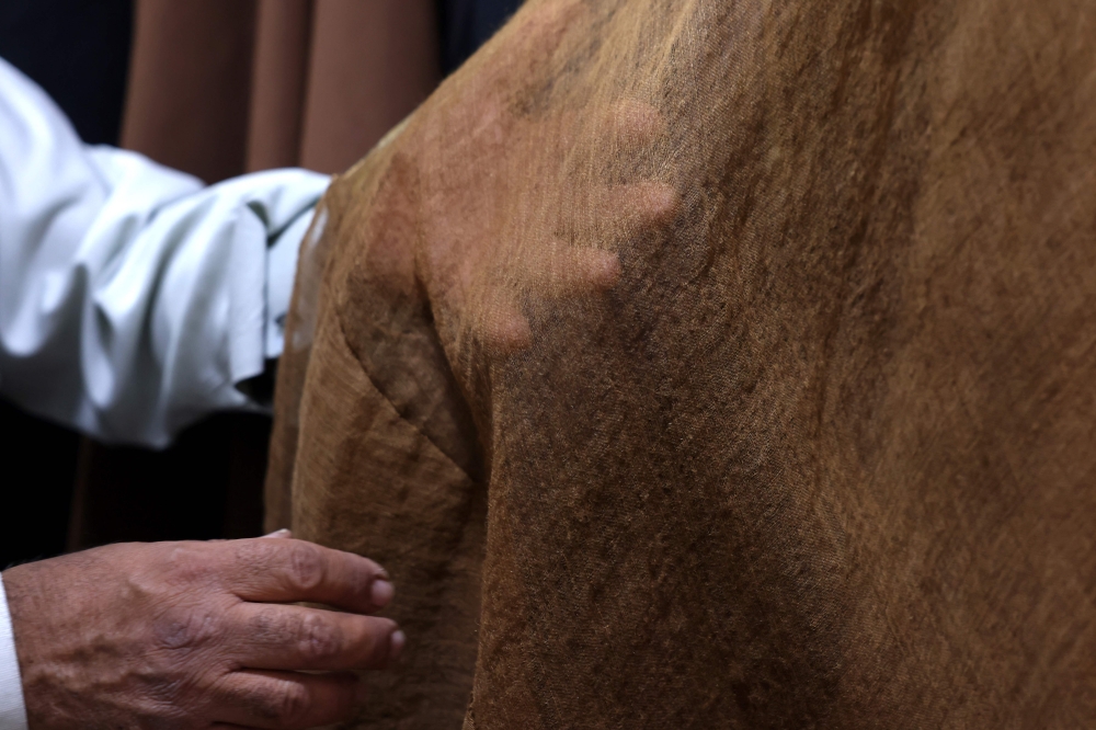 Habib showing the quality of his fabrics. — AFP