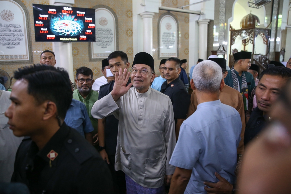 Prime Minister Datuk Seri Anwar Ibrahim greets the public as he leaves Masjid Jamek Raja Tun Uda in Shah Alam after performing Friday prayers March 28, 2025. — Picture by Yusof Mat Isa