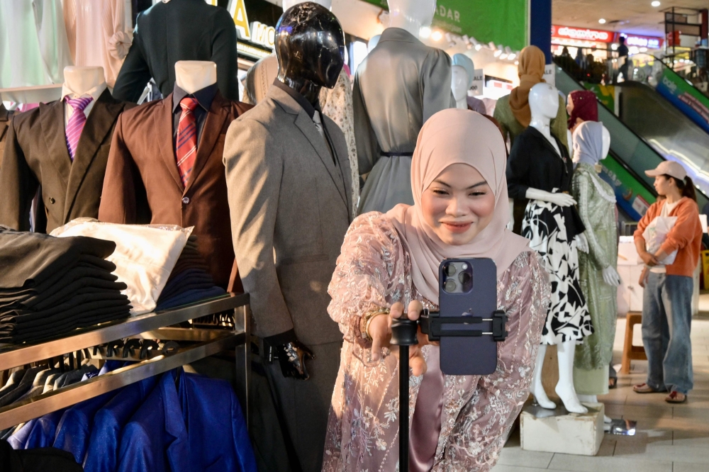 Malaysian Yaya Azmi setting up her smartphone to go ‘live’ at Tanah Abang Market in Jakarta March 6, 2025. — AFP pic