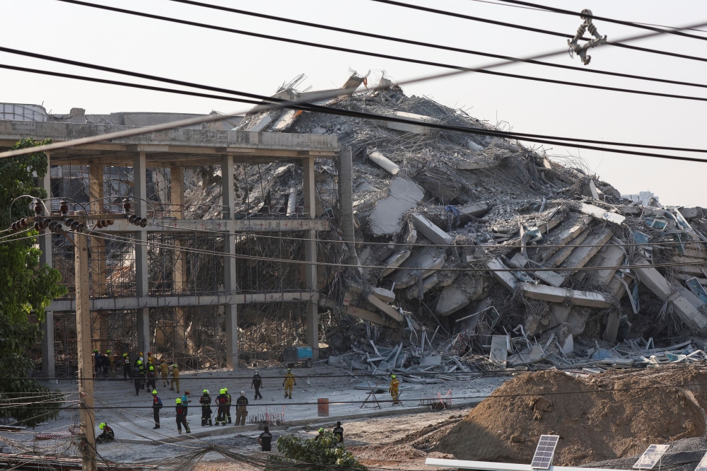 Rescue personnel stand near a building that collapsed in Bangkok March 28, 2025, after a strong earthquake struck central Myanmar today. — Reuters pic