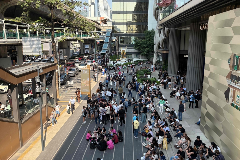 People gather outside a shopping mall in Bangkok March 28, 2025, after an earthquake in central Myanmar. — AFP pic