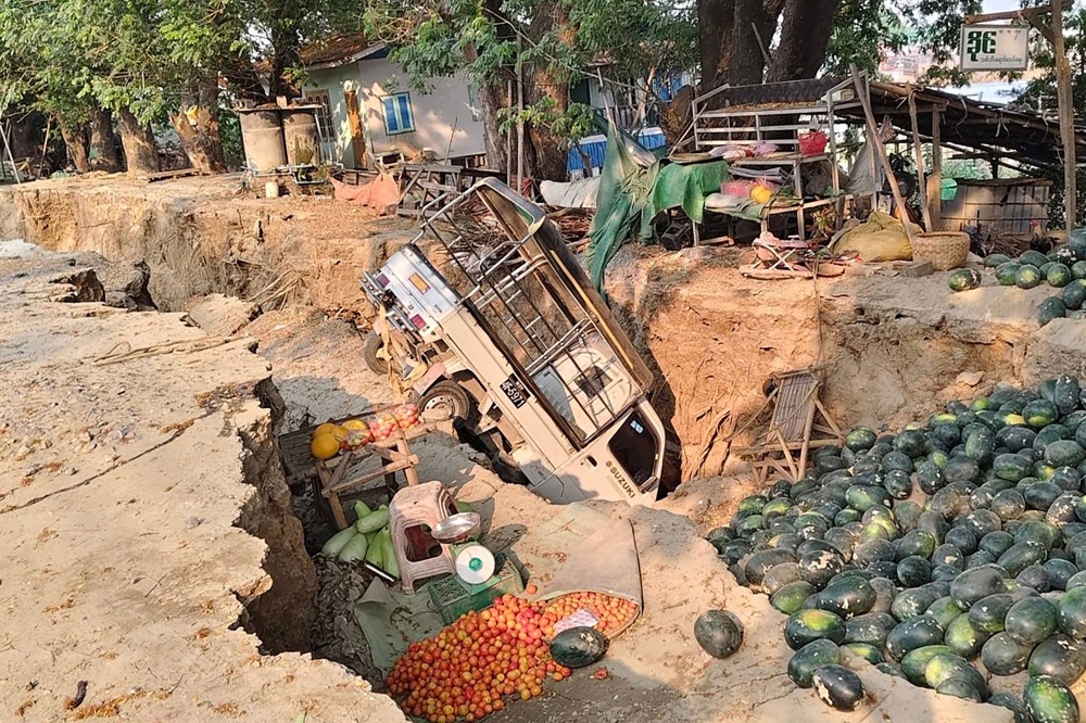 This UGC photo taken and posted by Hla Myo Aung on Facebook on March 28, 2025 shows a vehicle stuck in a crack in the ground next to spilled watermelons and vegetables in Sagaing, following the earthquake. — AFP pic/Courtesy of Facebook user Hla Myo Aung