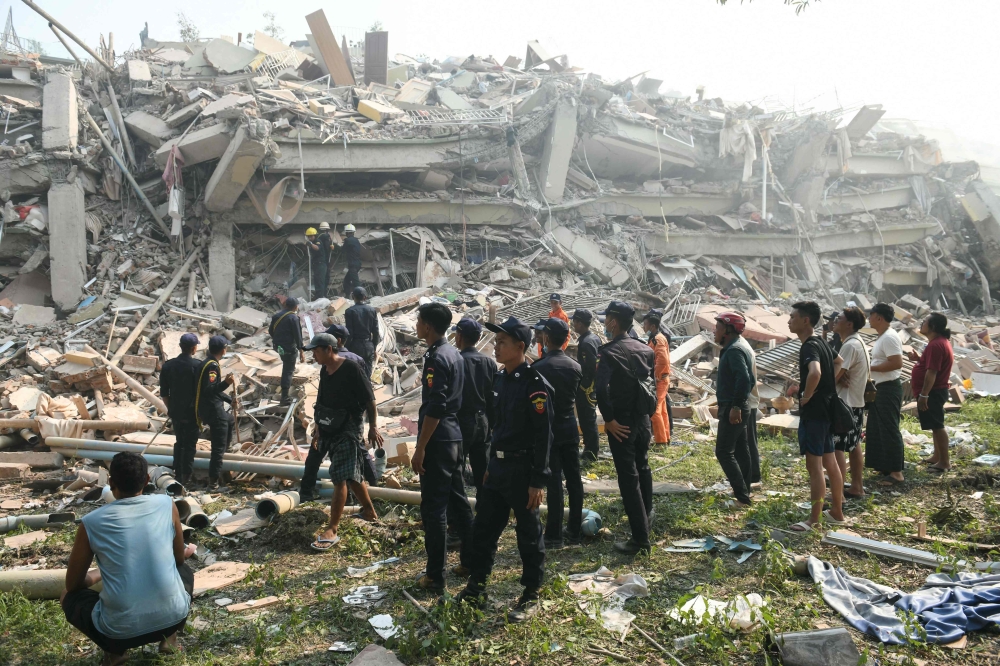 People watch as rescuers search for survivors trapped in the collapsed Sky Villa Condominium building in Mandalay on March 29, 2025. — AFP pic