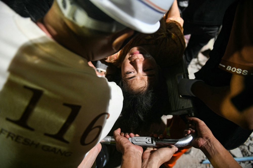 Phyu Lay Khaing is rescued from the rubble of the collapsed Sky Villa Condo apartment building on March 29, 2025. — AFP pic