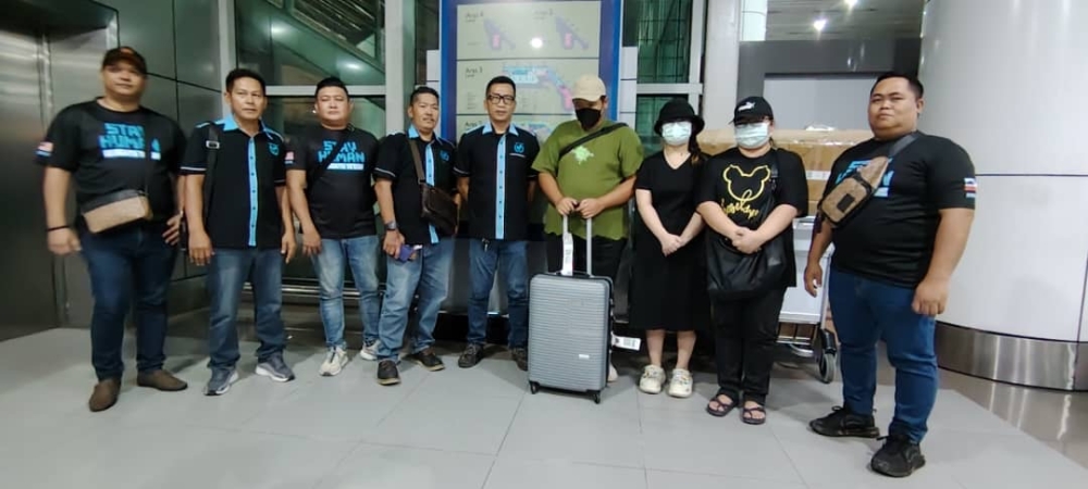 Jerry Jaimeh (centre) and the Malaysian Humanitarian International Organisation team with Grayson’s family at KKIA yesterday. — The Borneo Post pic