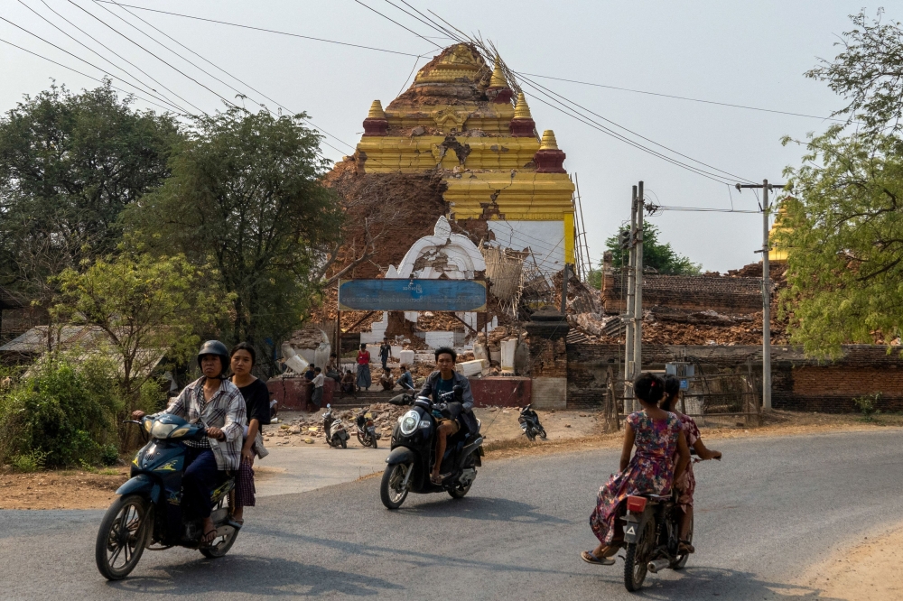 People ride past a pagoda damaged during a strong earthquake, in Mandalay, Myanmar, March 29, 2025. — Reuters pic